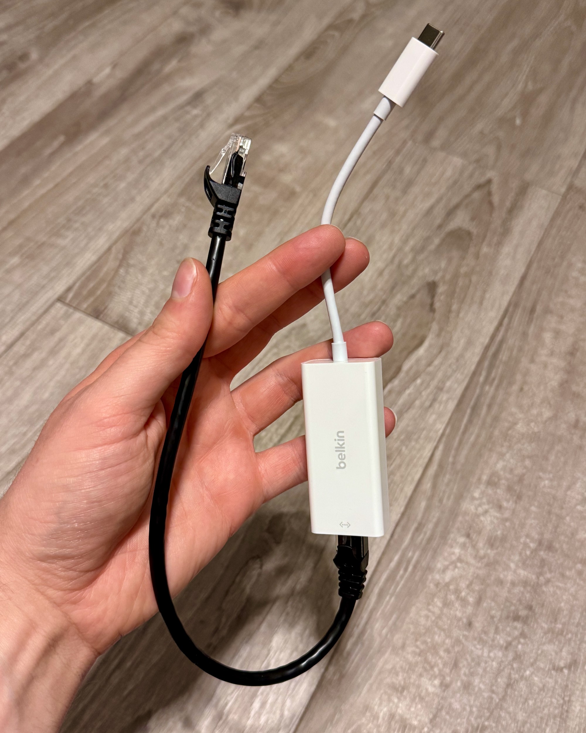 A Belkin USB-C to ethernet dongle attached to a 1ft black ethernet patch cable