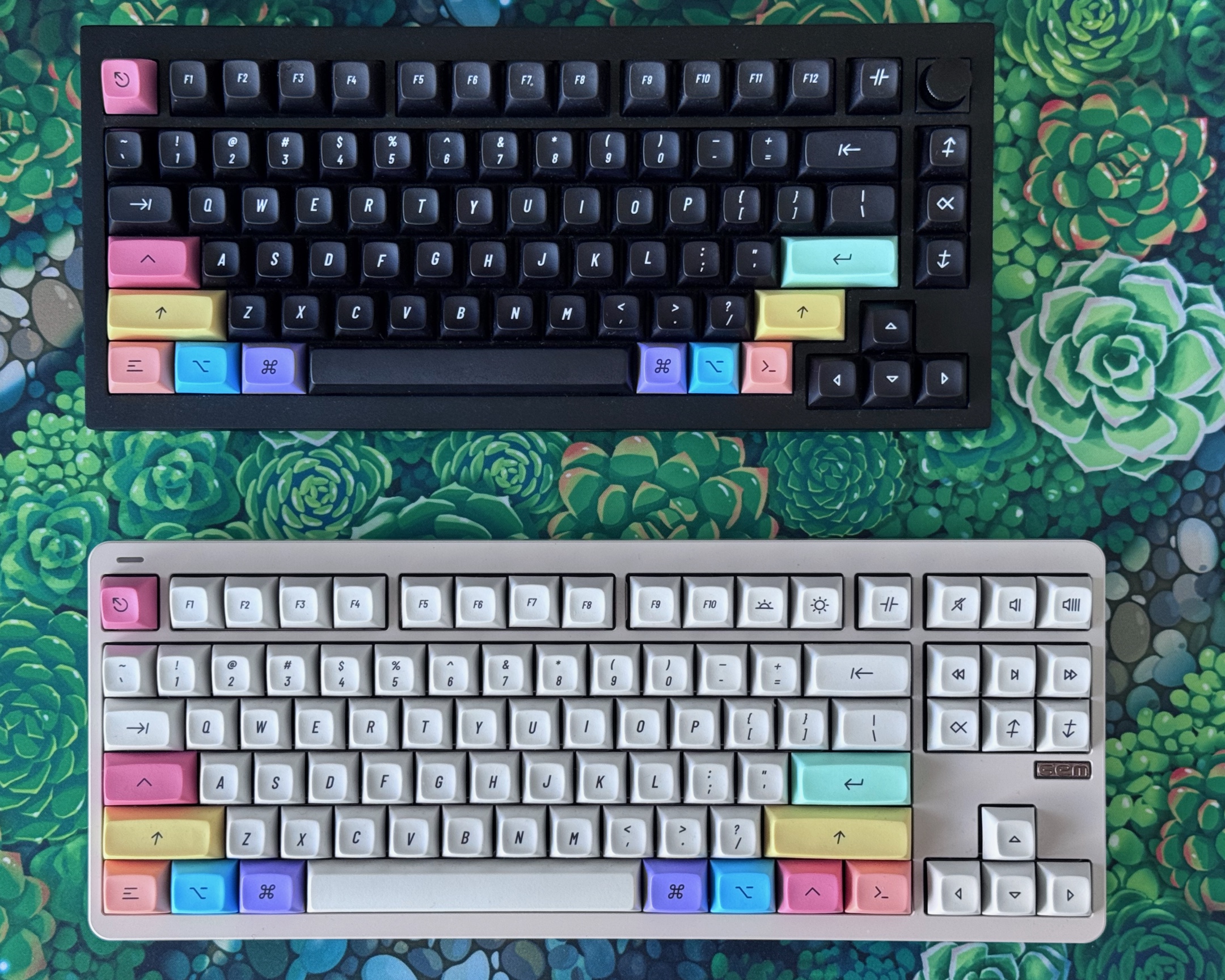 A photograph of two mechanical keyboards, taken from above. There is a black one and an off-white one, each with accent-coloured key caps, using pastel versions of the colours of the old six-colour Apple logo